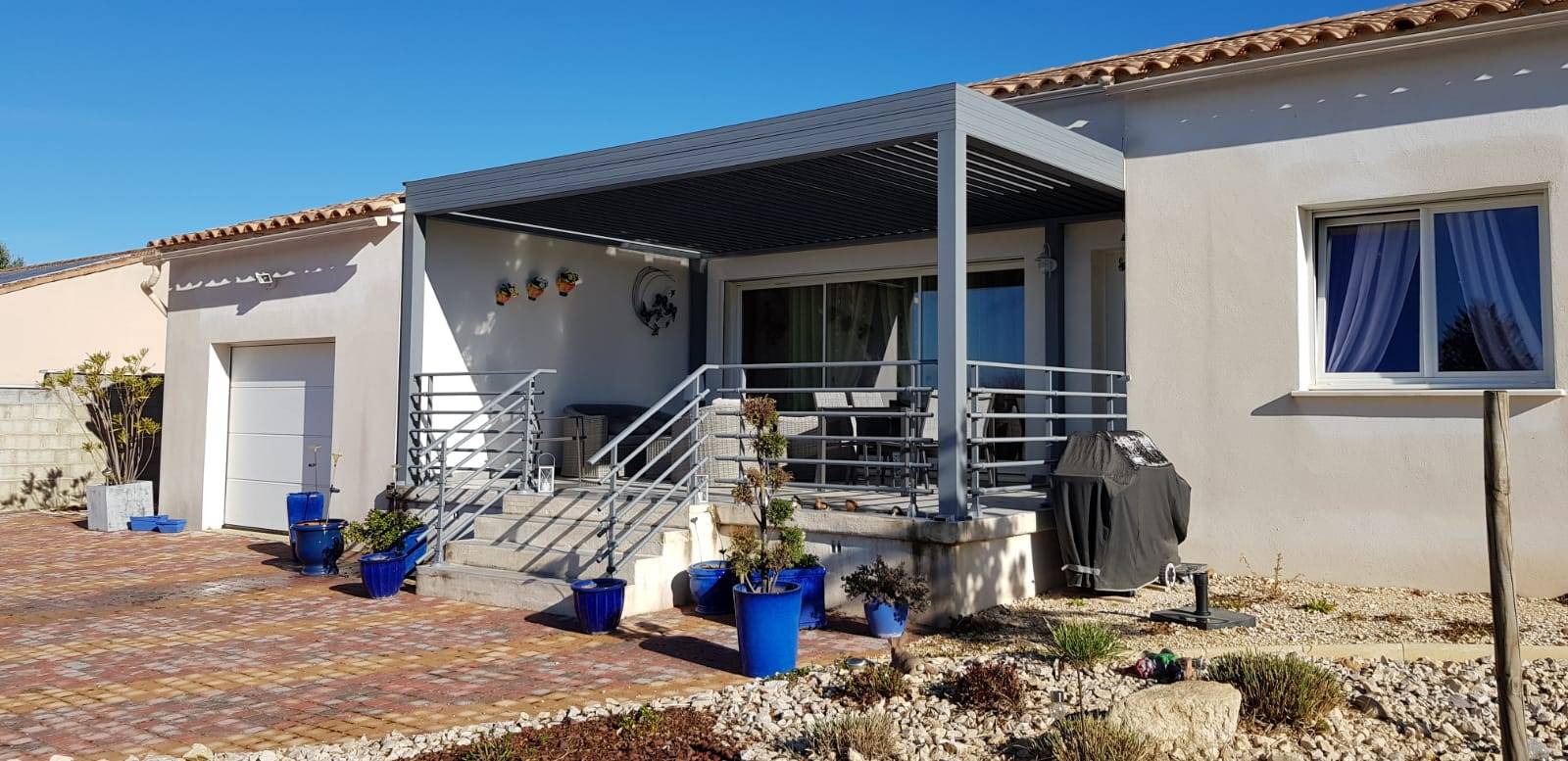 Installation d'une pergola en aluminium de couleur gris sur une terrasse orientée plein sud vers Bagnols