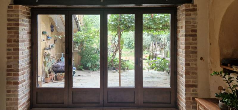 Menuiserie aluminium repliable quatre vantaux coloris rouille à Seillans pour ouvrir largement la maison sur le jardin