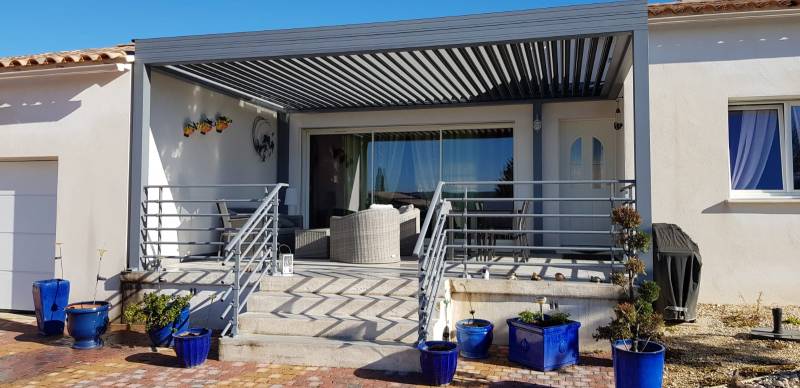 Installation d'une pergola en aluminium de couleur gris sur une terrasse orientée plein sud vers Bagnols