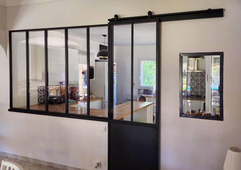 Création d’une verrière aluminium noire avec porte coulissante à Saint-Victor-la-Coste pour structurer élégamment une cuisine ouverte