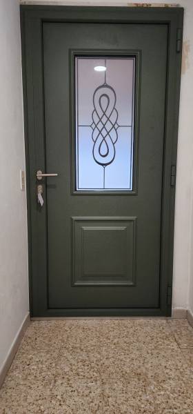 Installation d’une porte d’entrée aluminium verte avec vitrage décoratif à Saint-Laurent-des-Arbres pour valoriser durablement une habitation existante